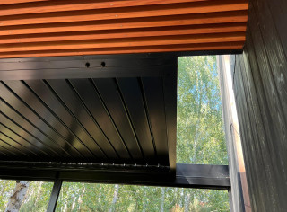 Pergola lamelowa ze stałą szybą w trapezie