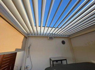 Pergola lamelowa Sun Breaker. Dodatkowo, rolety boczne ZIP Screen, promiennik ciepła oraz oświetlenie LED. Kolor konstrukcji RAL 1013