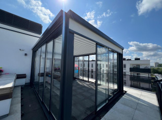 Louvered roof pergola with glass sliding walls and roller shutters on sides.Featuring LED RGBW lighting and IR heater.